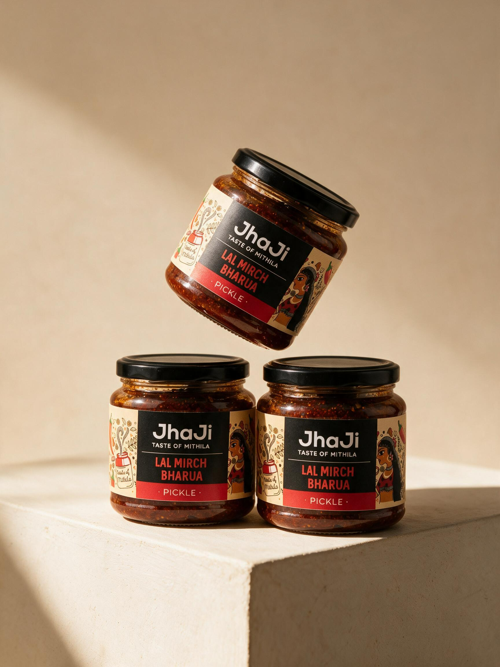 Three product jars arranged as a floating sculptural stack on a beige studio pedestal